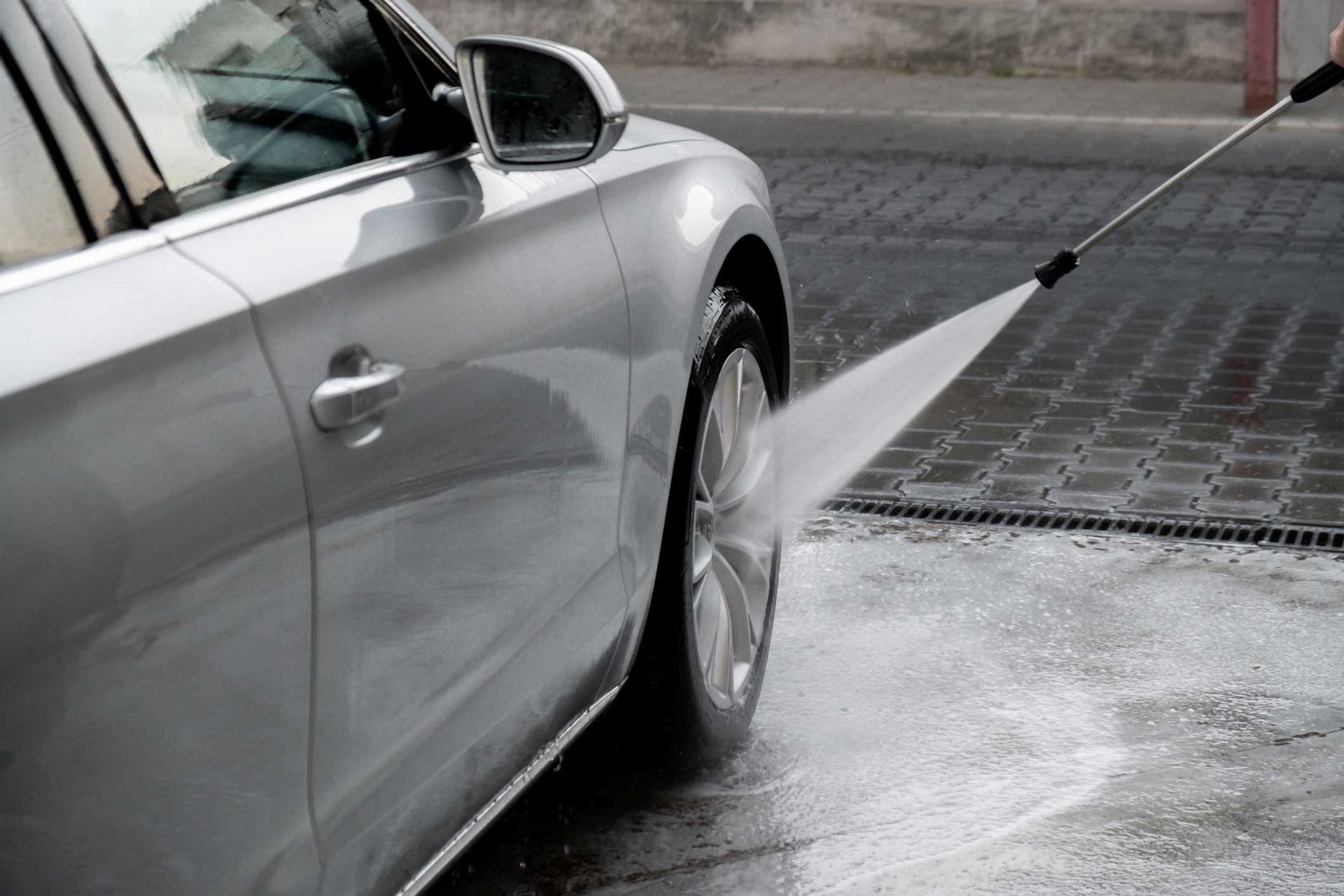 Washing luxury silver car on touchless car wash.