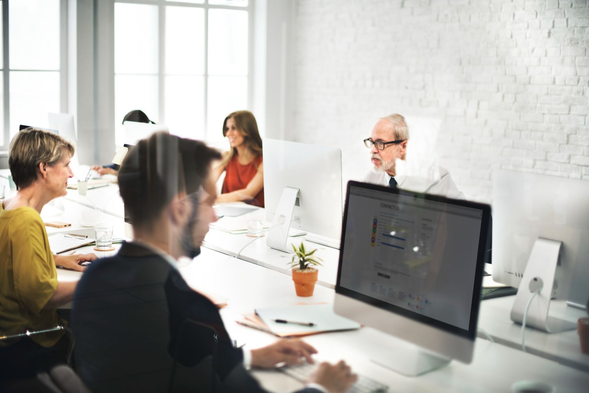 People working at computers in a bright office.