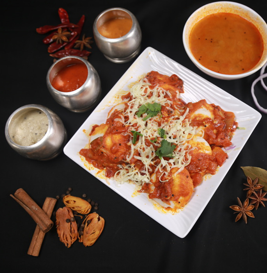 Plate of food covered in sauce and cheese, surrounded by small bowls of sauces and spices.