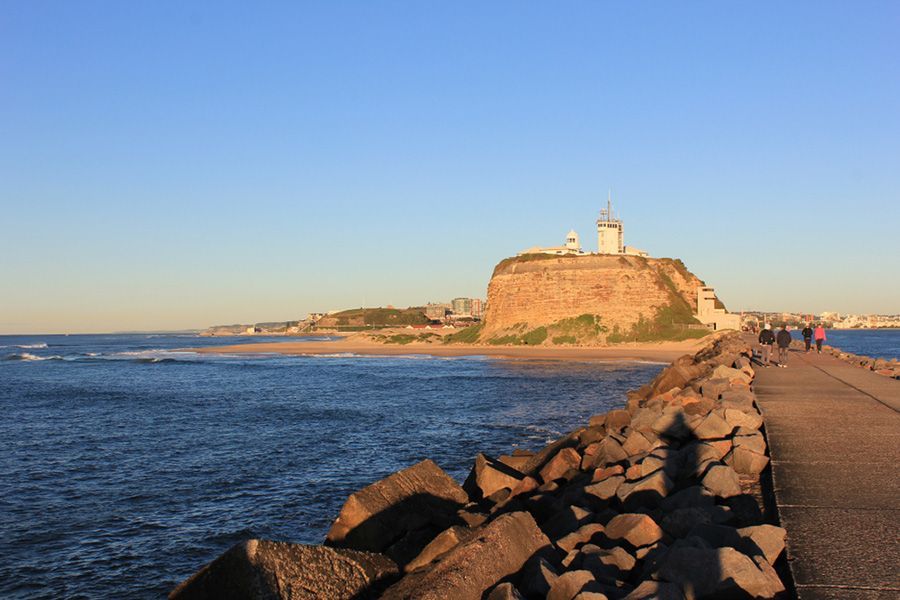 A Lighthouse on Top of A Rocky Hill Overlooking the Ocean — Novocastrian Removals & Storage in Newcastle, NSW