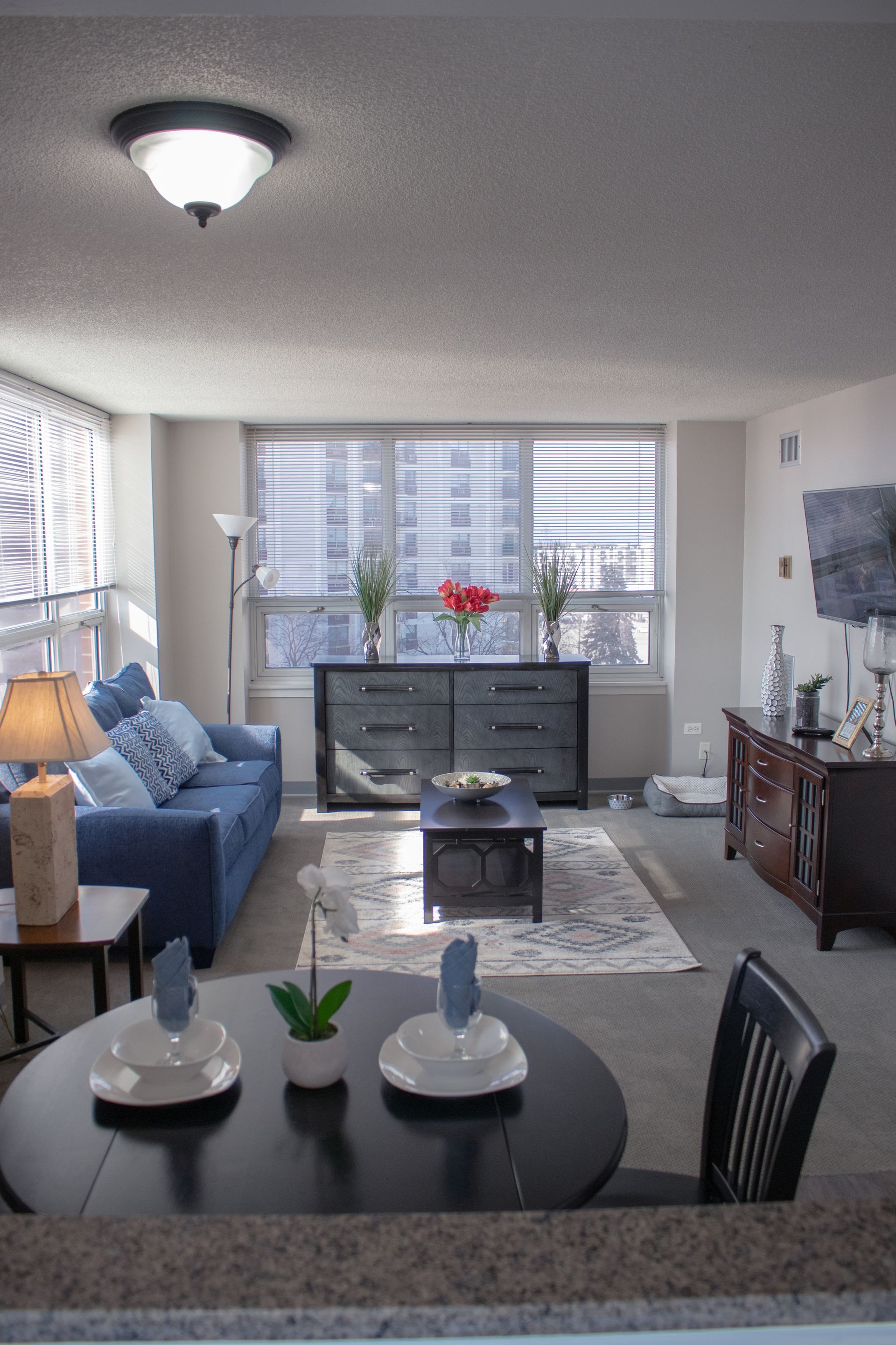 A living room with a table and chairs and a blue couch