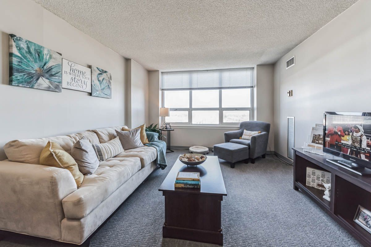 A living room with a couch , chair , coffee table and television.
