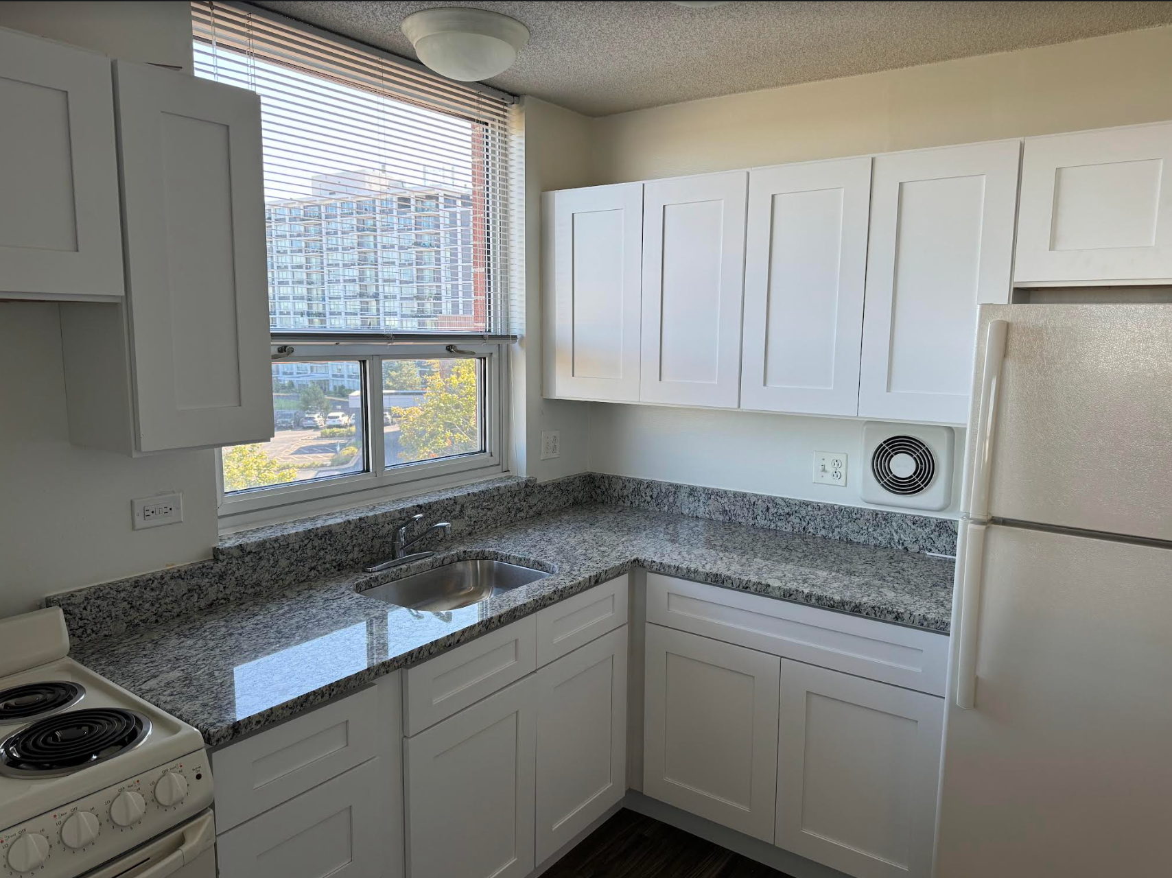 A kitchen with white cabinets and granite counter tops