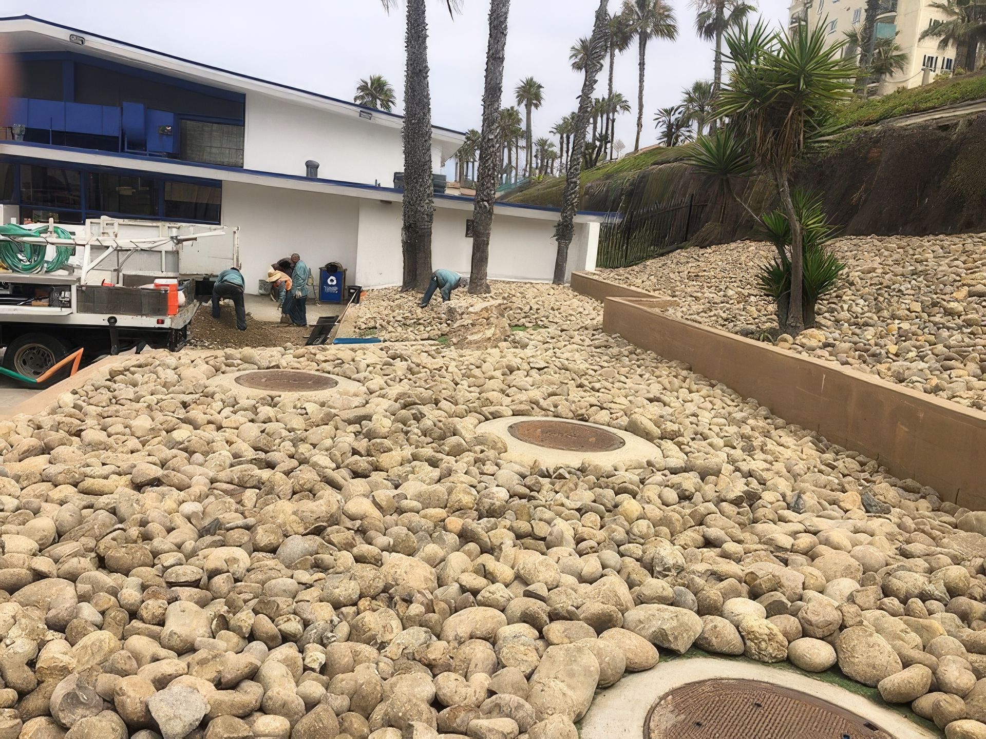An organized arrangement of rocks is sitting in front of a house.