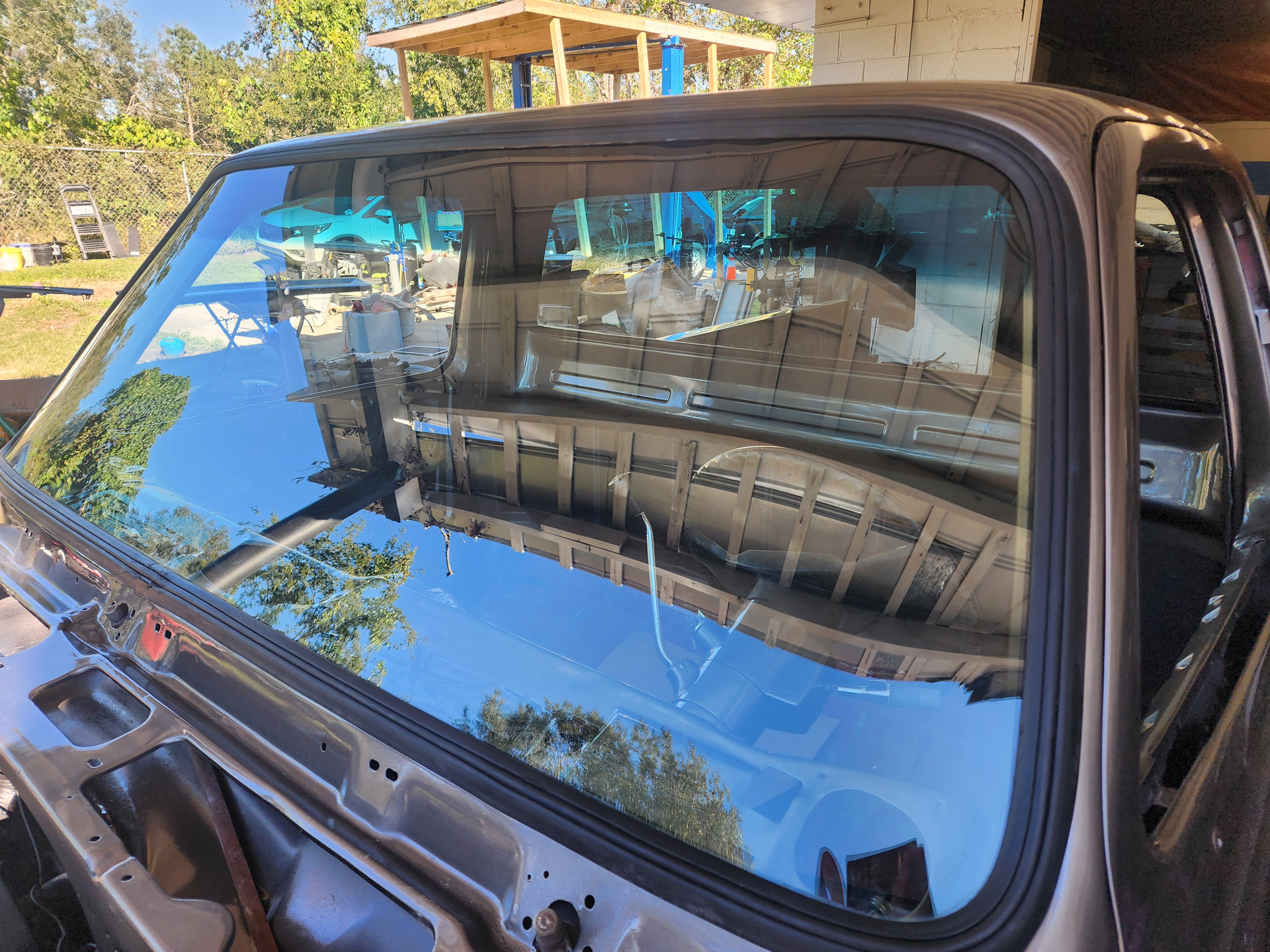 Person using a tool to repair a cracked windshield.