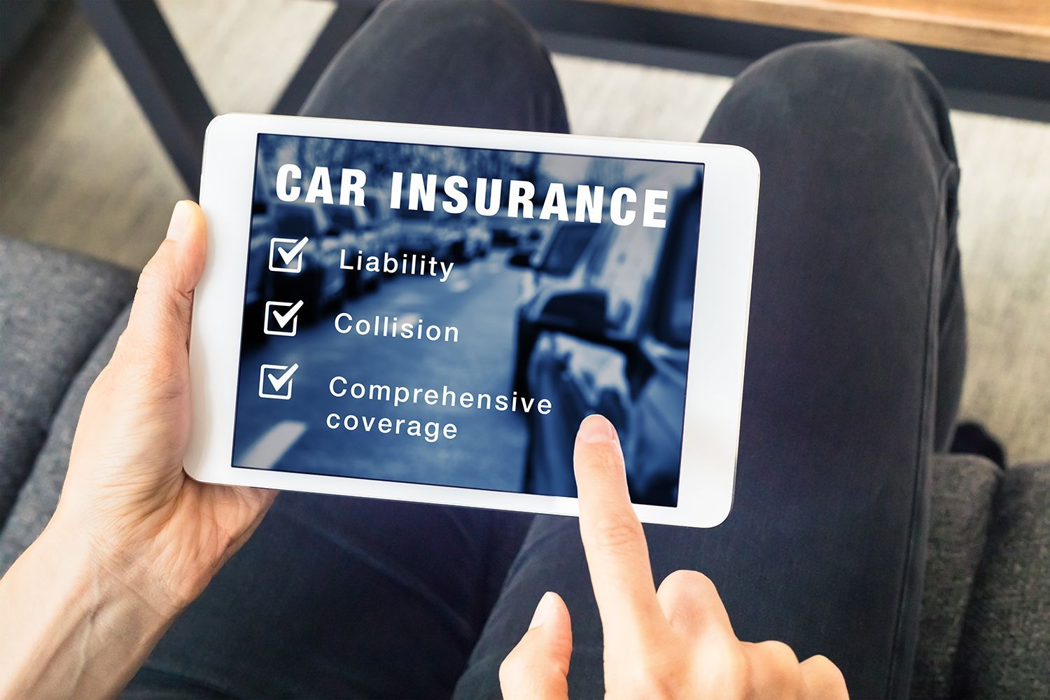 Hands using a tablet showing car insurance coverage options with checkboxes. Hands using a tablet showing car insurance coverage options with checkboxes.