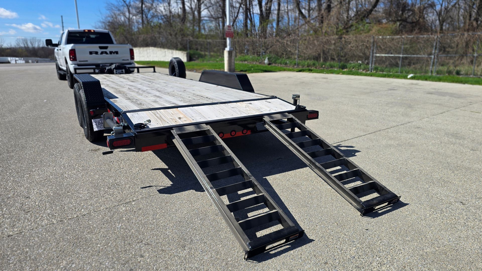 Tow truck with ramp lowered in an empty parking lot on a sunny day
