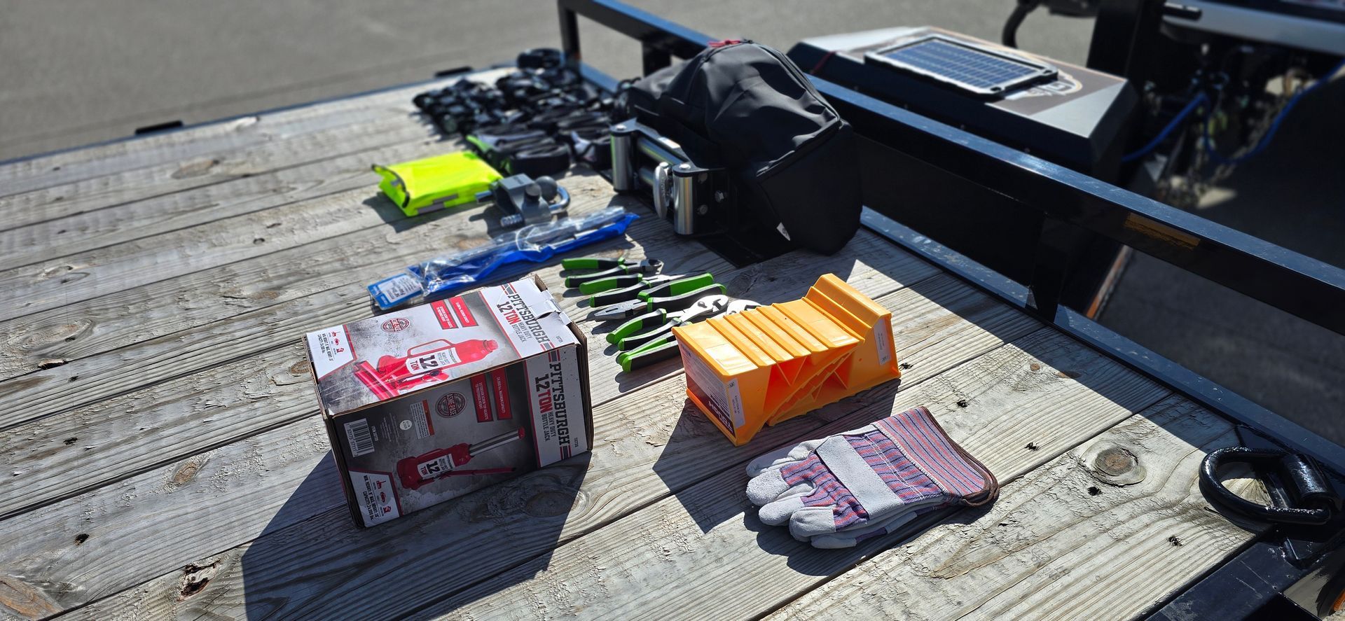 Pack of assorted snacks and candy bars laid out on a wooden deck beside a black railing.