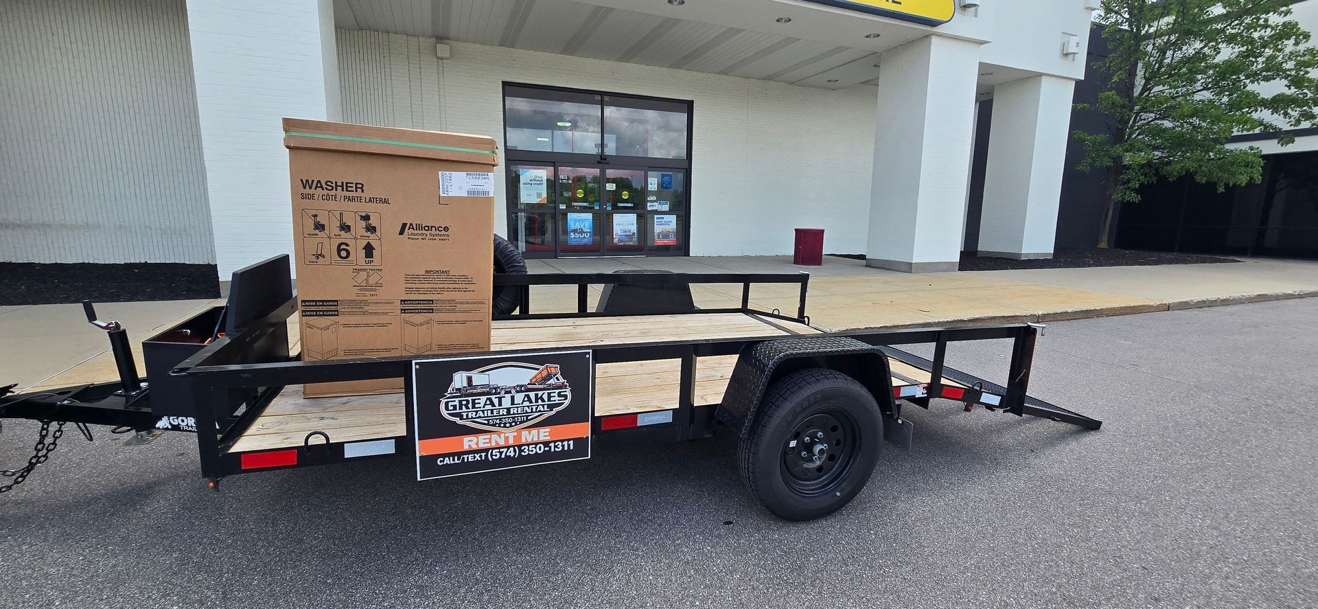 Cargo trailer with a cardboard box on the platform parked outside a building
