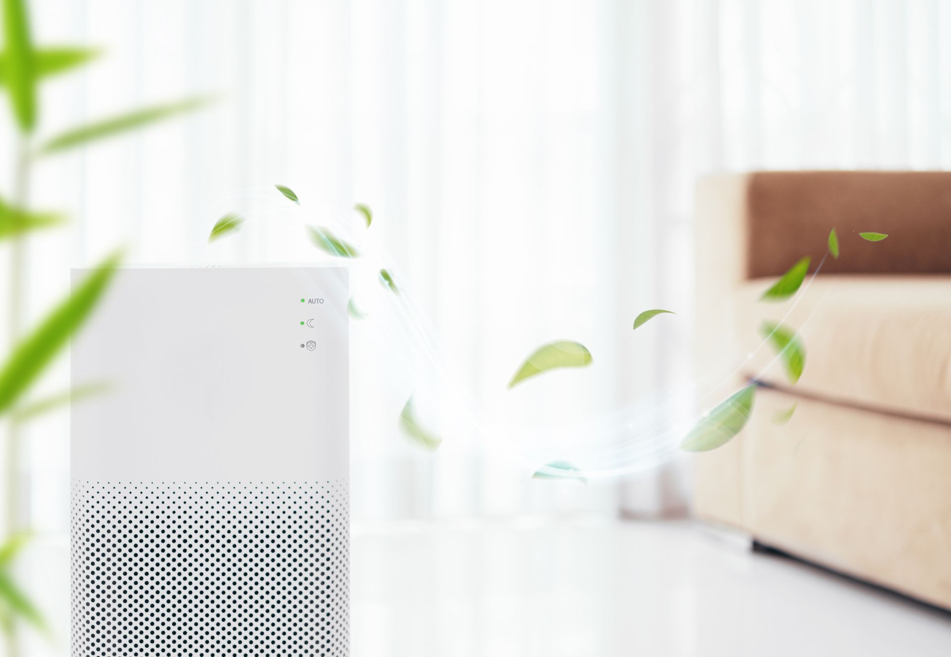 White air purifier in a bright room with floating green leaves near a sofa