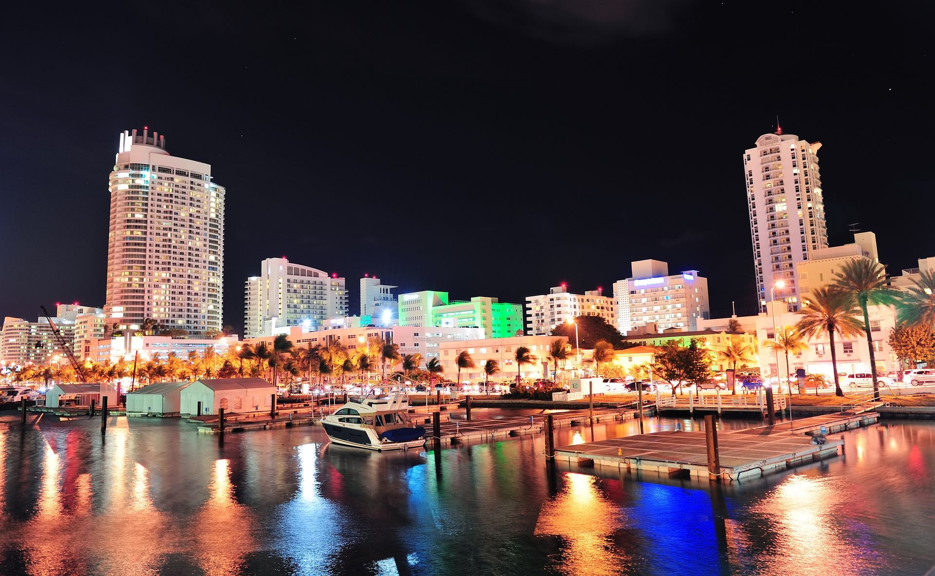 a city skyline at night with boats in the water