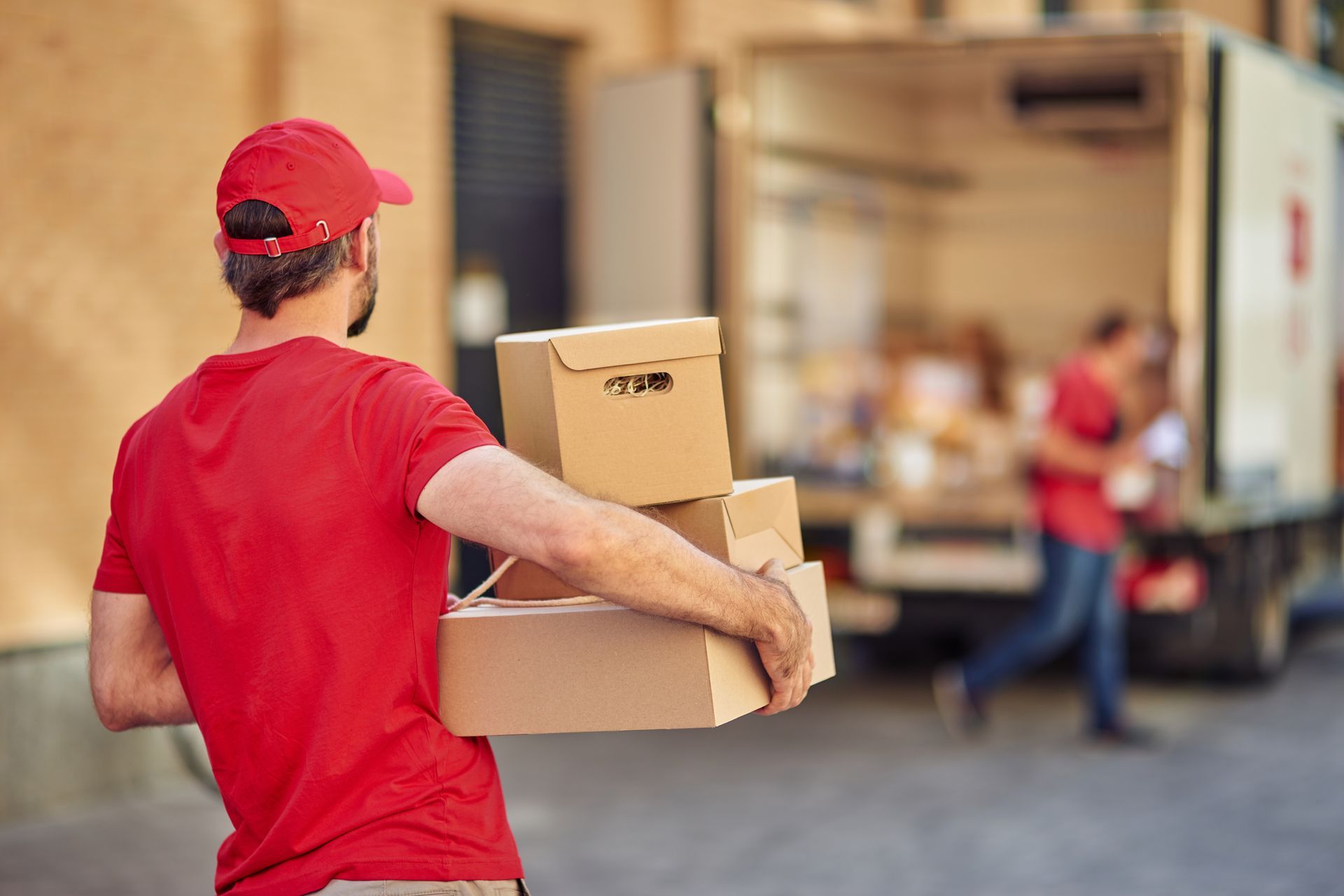 A man is carrying boxes. A man is carrying boxes.
