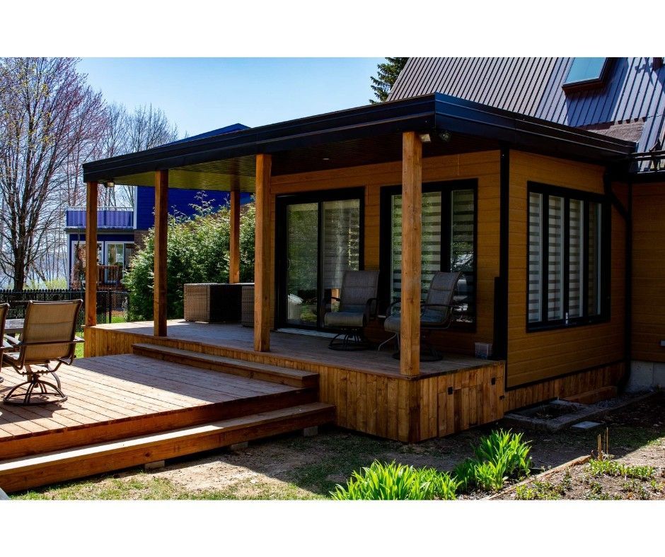Une petite maison avec un porche et des chaises.
