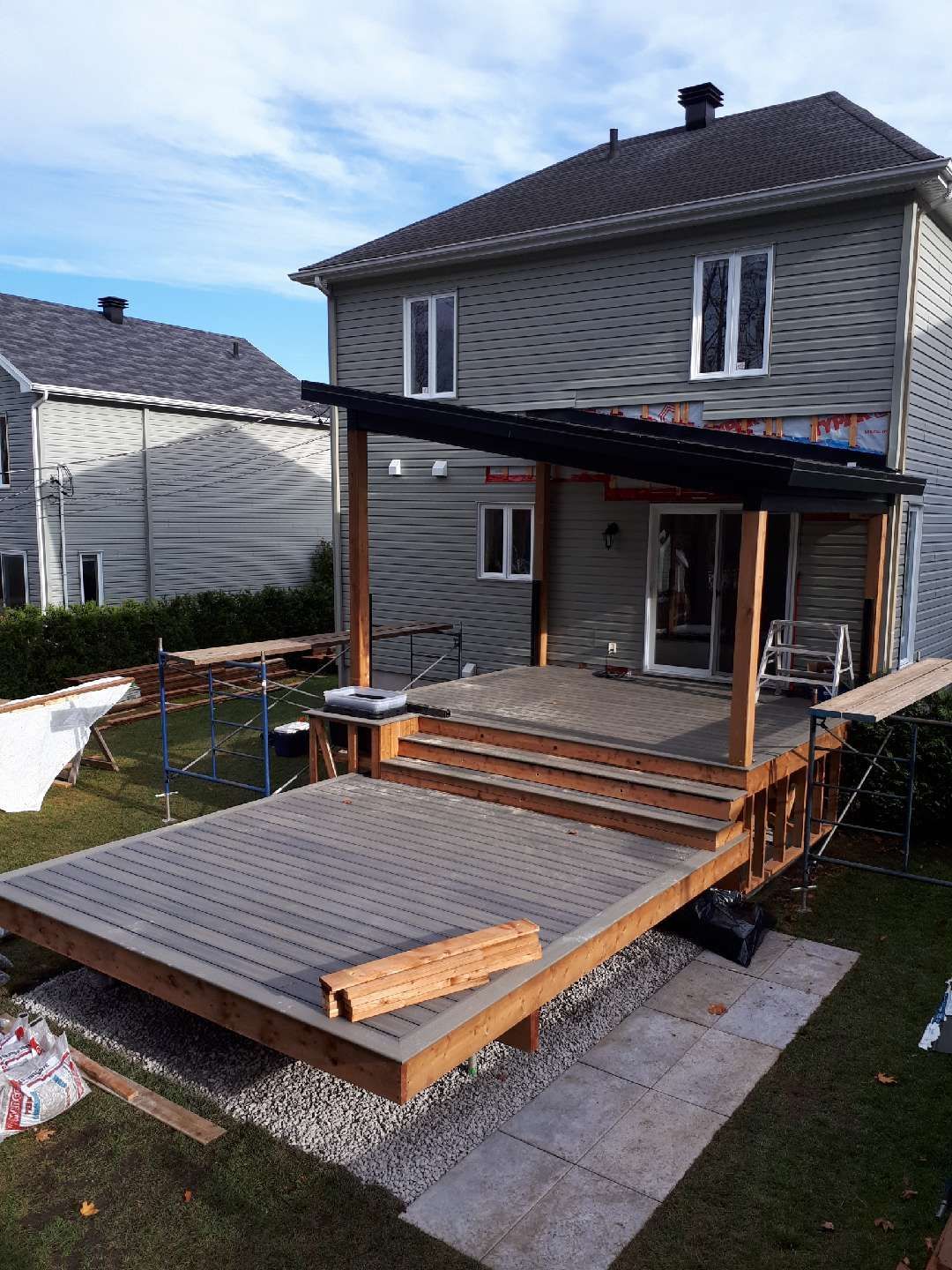 Une terrasse en bois est en cours de construction dans la cour d'une maison.