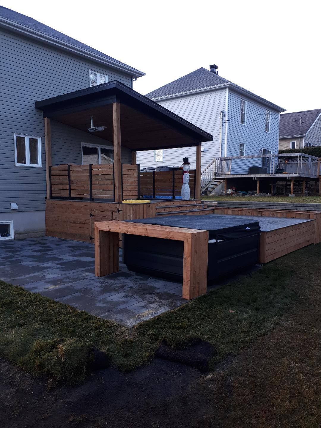 Une cour arrière avec une terrasse en bois et un bain à remous.