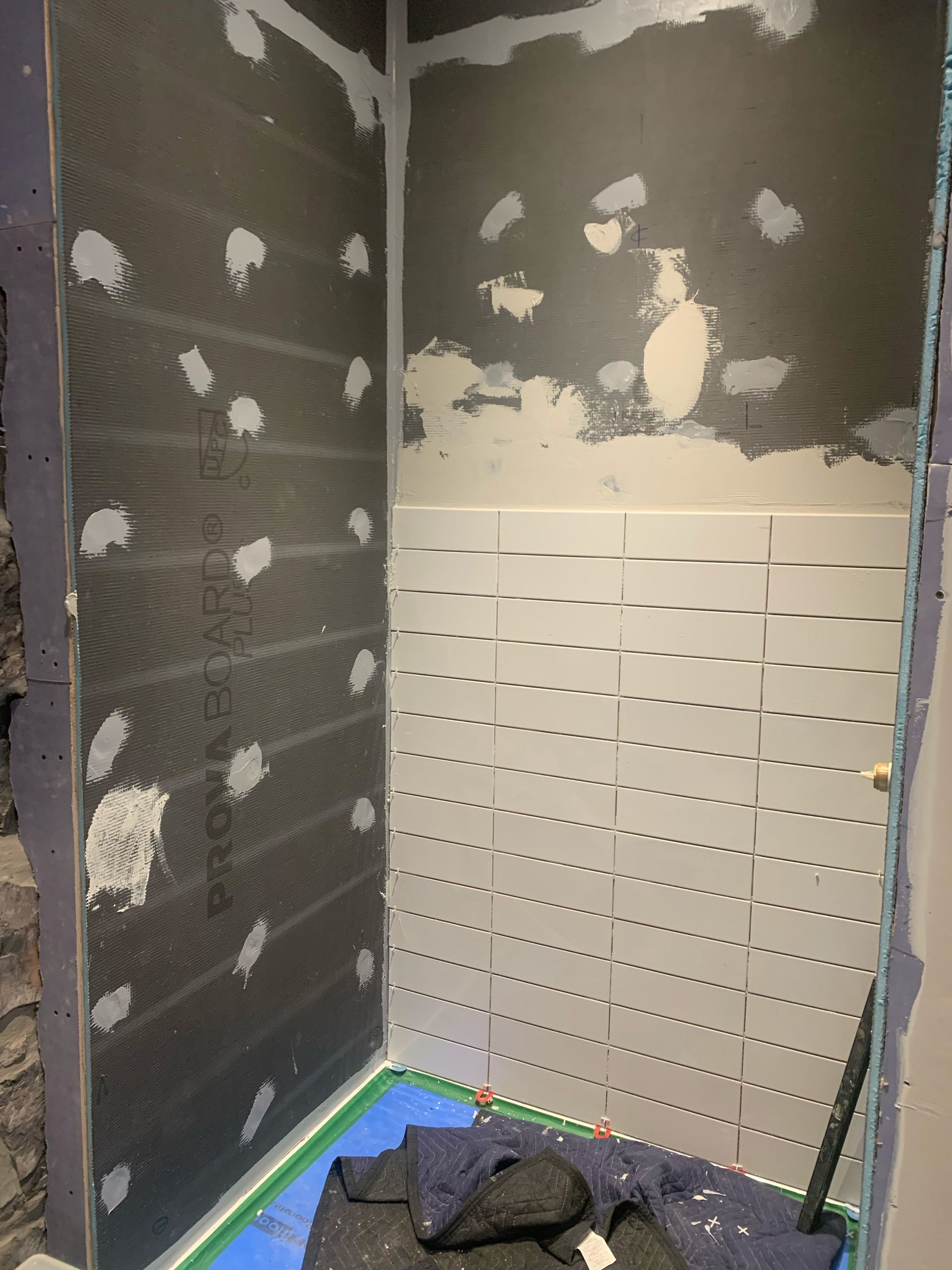 Une salle de bain est en cours de rénovation et le carrelage est en cours de pose.