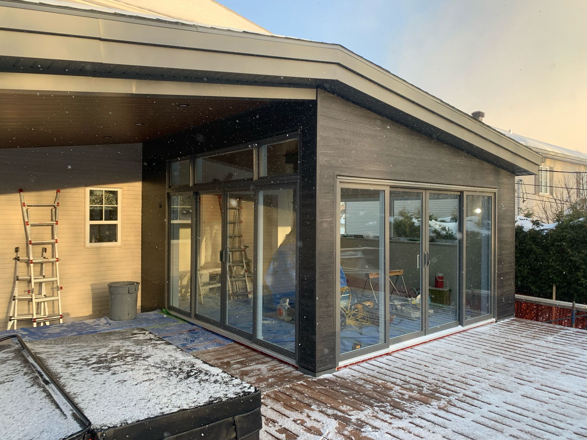 Une maison avec beaucoup de fenêtres et de la neige au sol