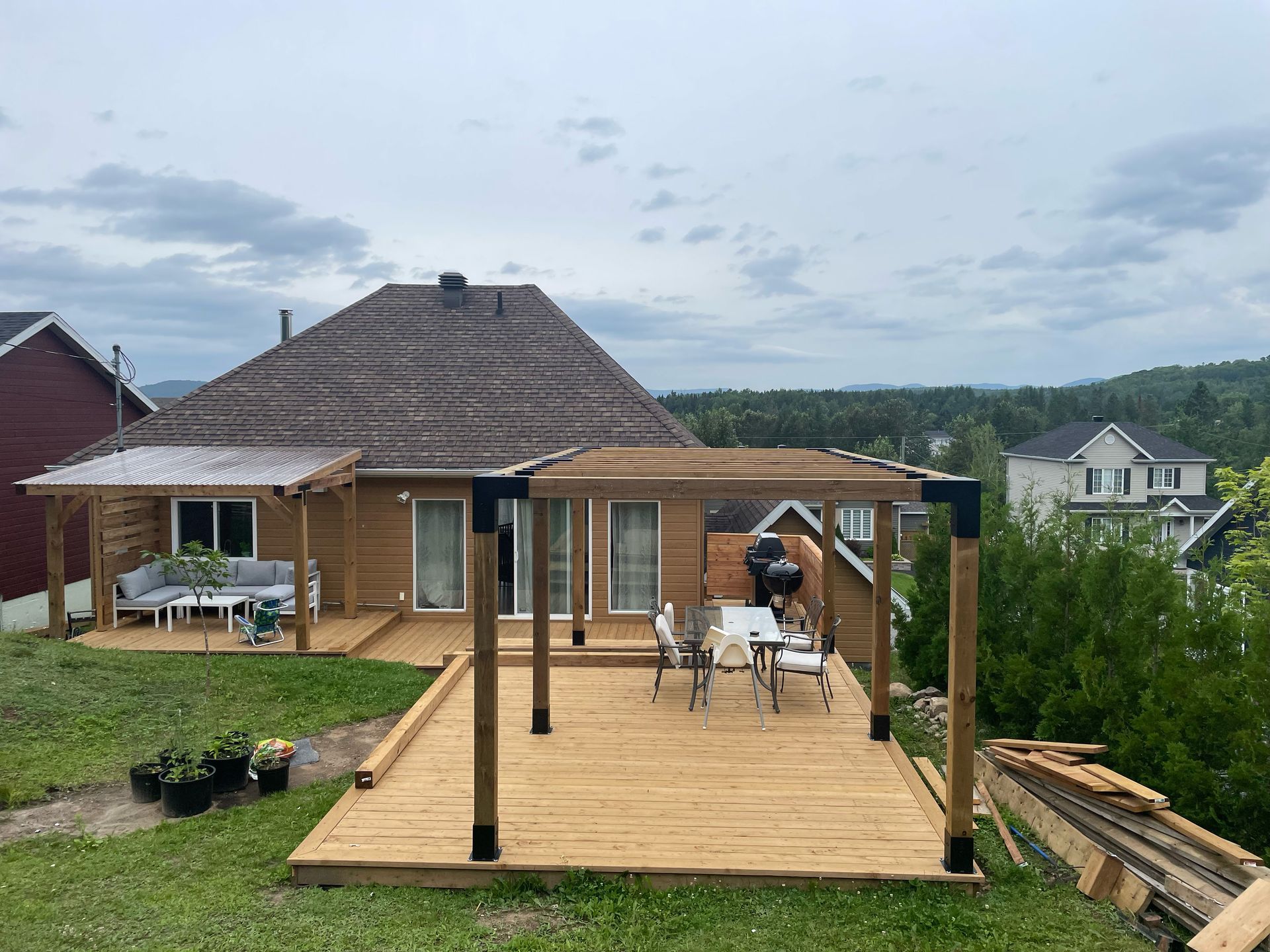 Une terrasse en bois est en cours de construction devant une maison.