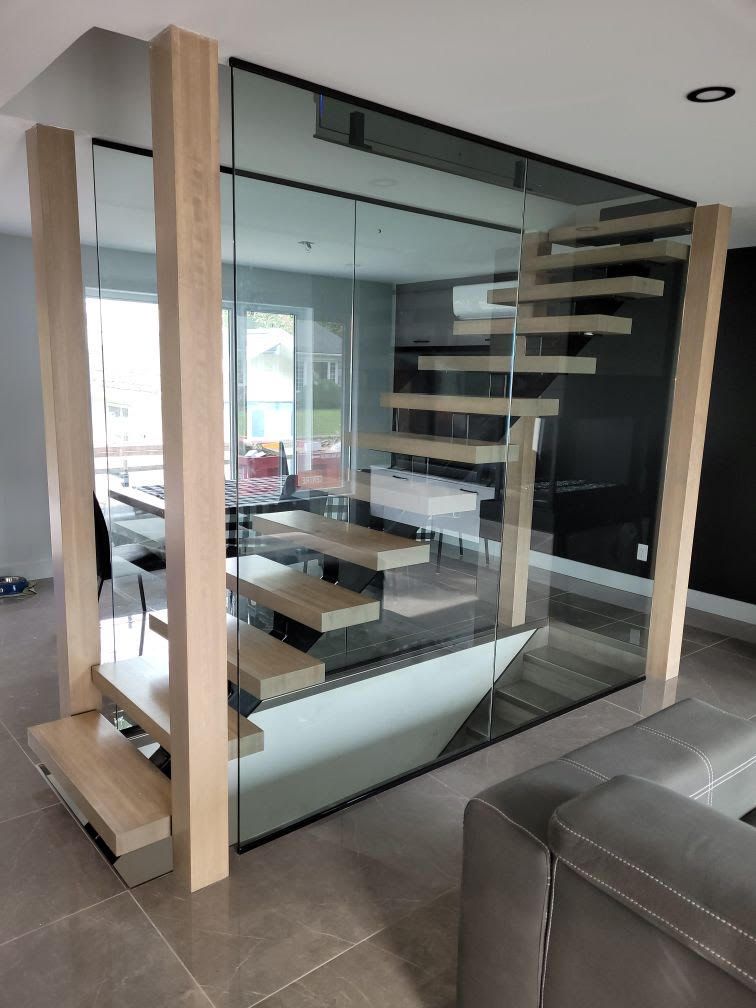 Un escalier est entouré de verre dans un salon.
