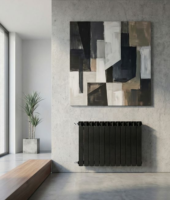 Habitación minimalista con arte mural abstracto en negro, blanco y gris sobre un radiador negro y una planta en maceta.