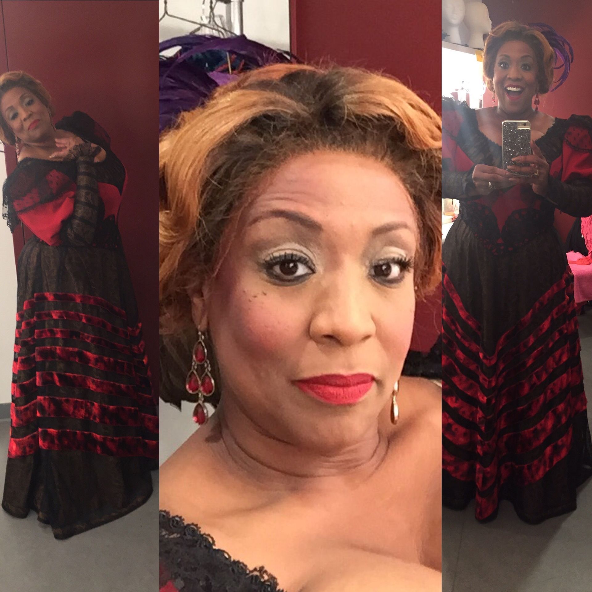 Woman in a black and red dress, red lips, wearing earrings, posing for selfies in a room.