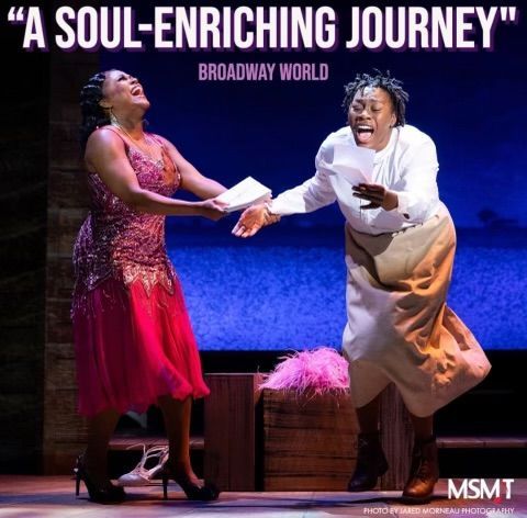 Two Black women on stage, singing. One in pink sequined dress, the other in beige skirt and white top. Blue backdrop.