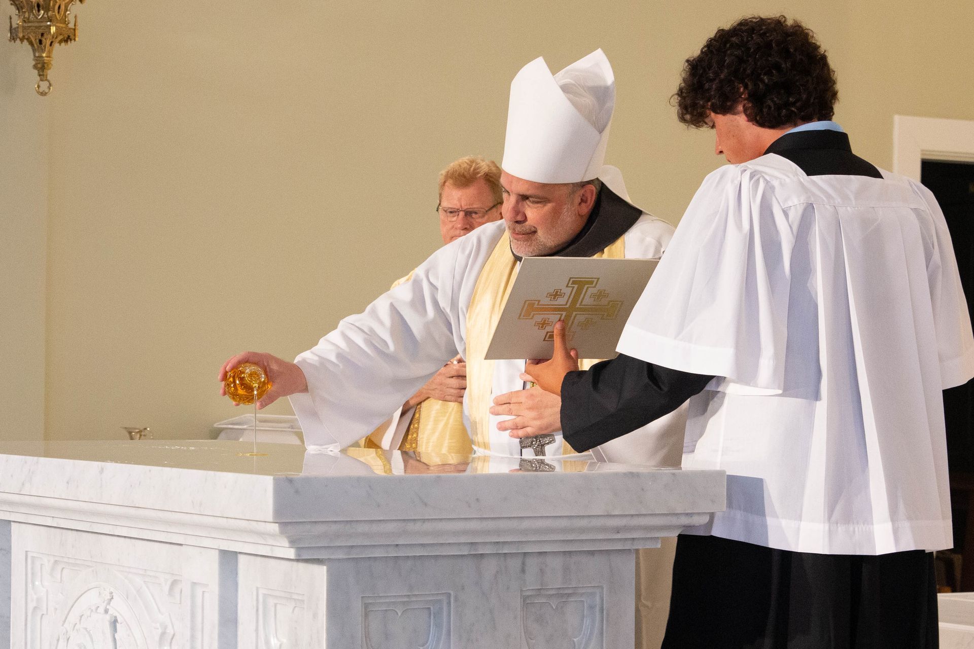 bishop stowe anointing oil on the new altar at st. luke img