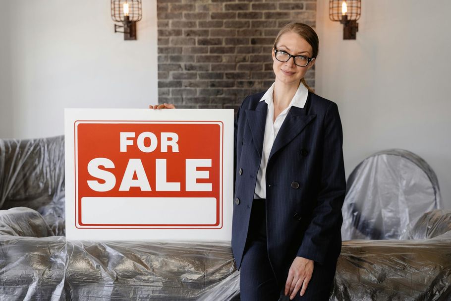 Woman in glasses stands beside a large red 