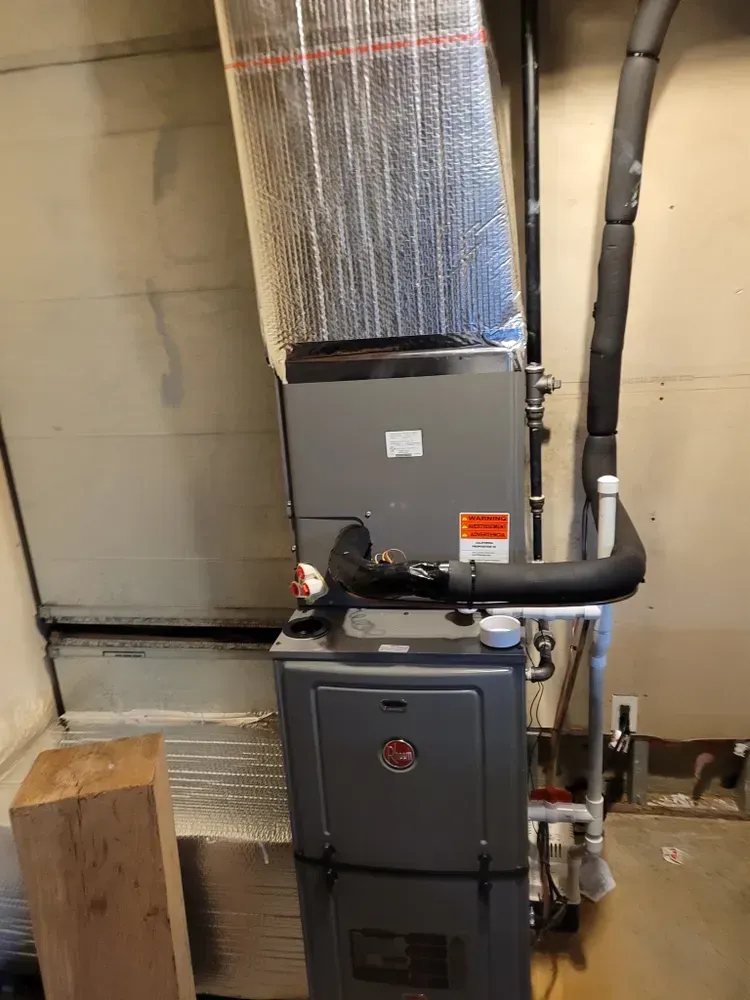 A Rheem furnace in a garage setting, with insulated ductwork.