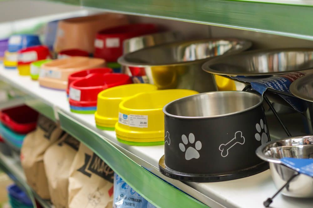 A Shelf Filled with Bowls and Bags of Dog Food — Hazells Farm & Fertilizer Services in Taminda, NSW