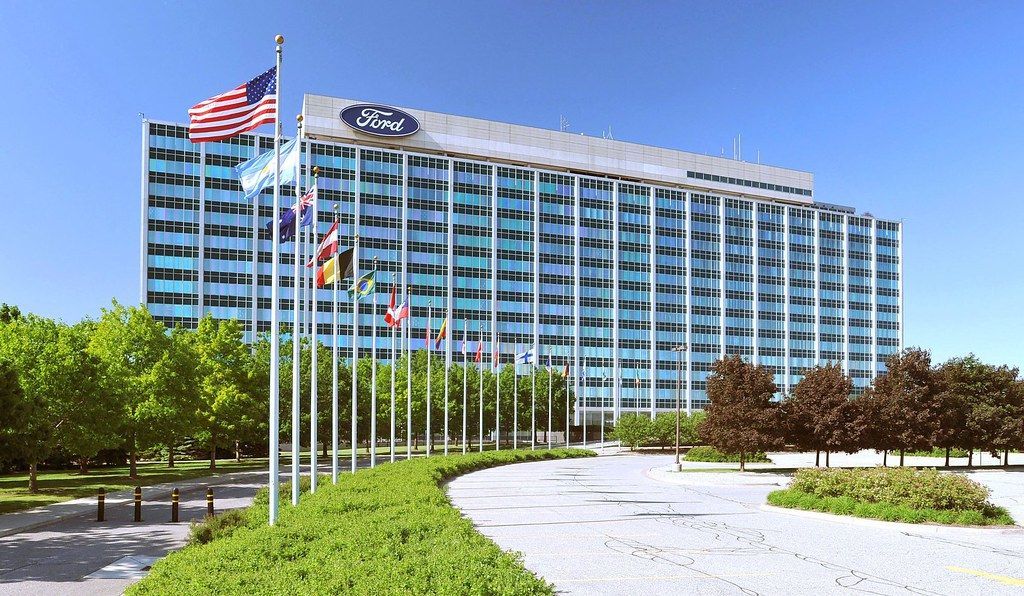 A large ford building with flags in front of it