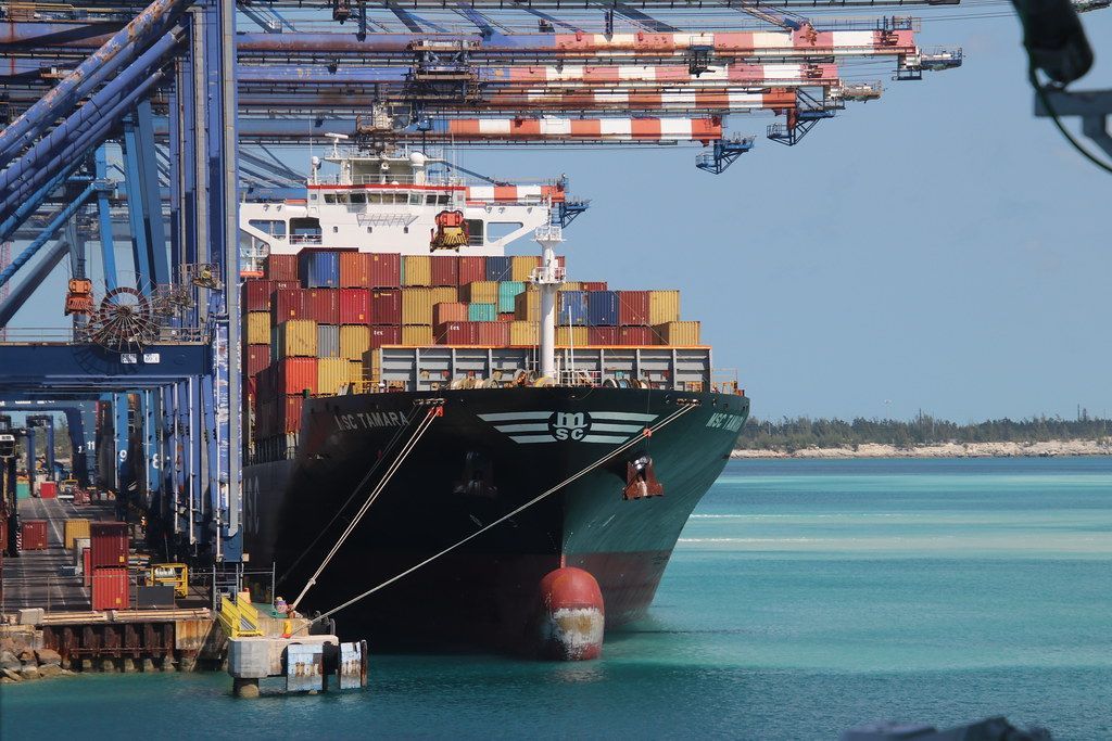 A large container ship is docked at a port.