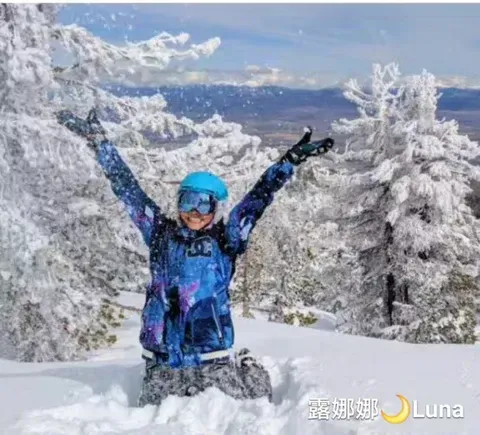 a person is kneeling in the snow with their arms in the air .