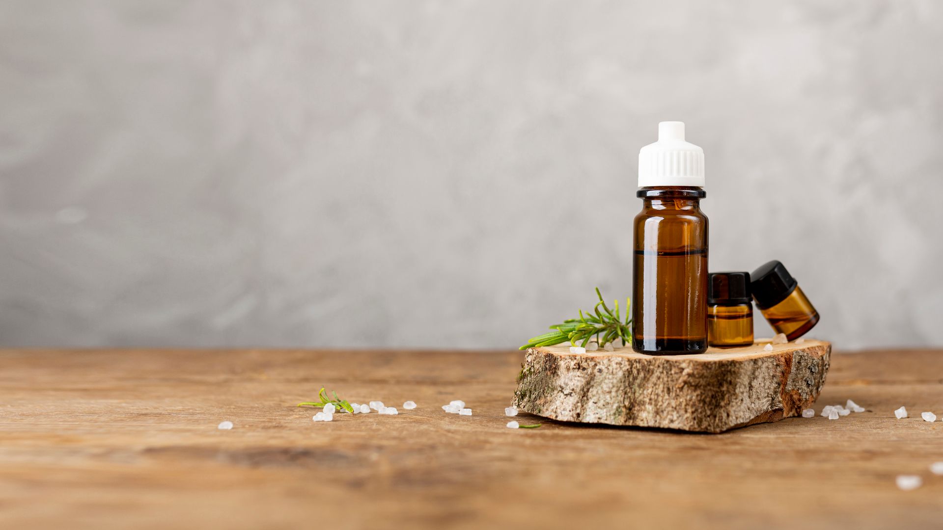 a bottle of essential oil sits on a wooden stump