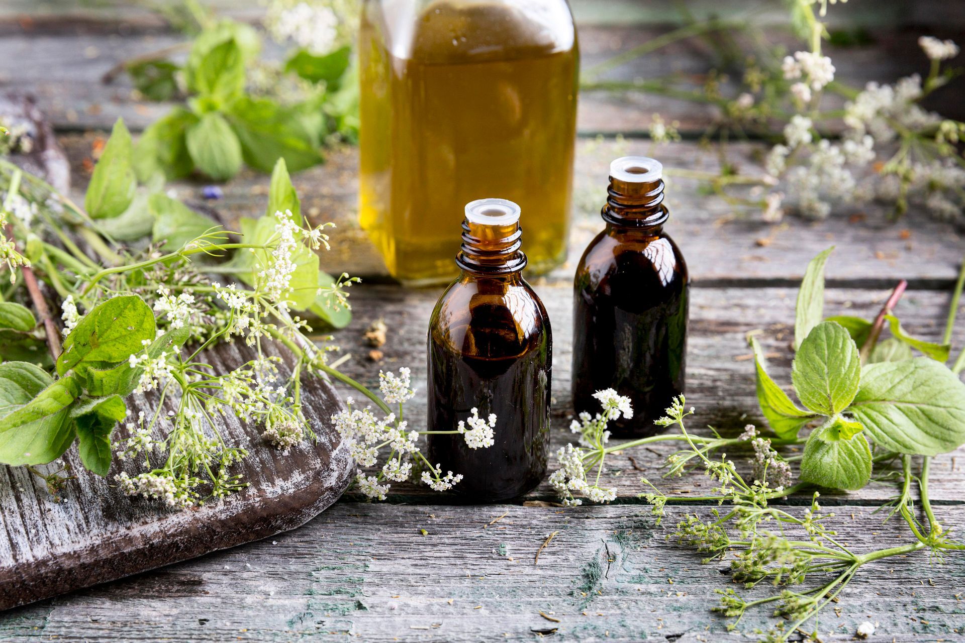 three bottles of essential oil are on a wooden table