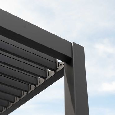 Dark gray metal pergola beams and support post against a cloudy sky