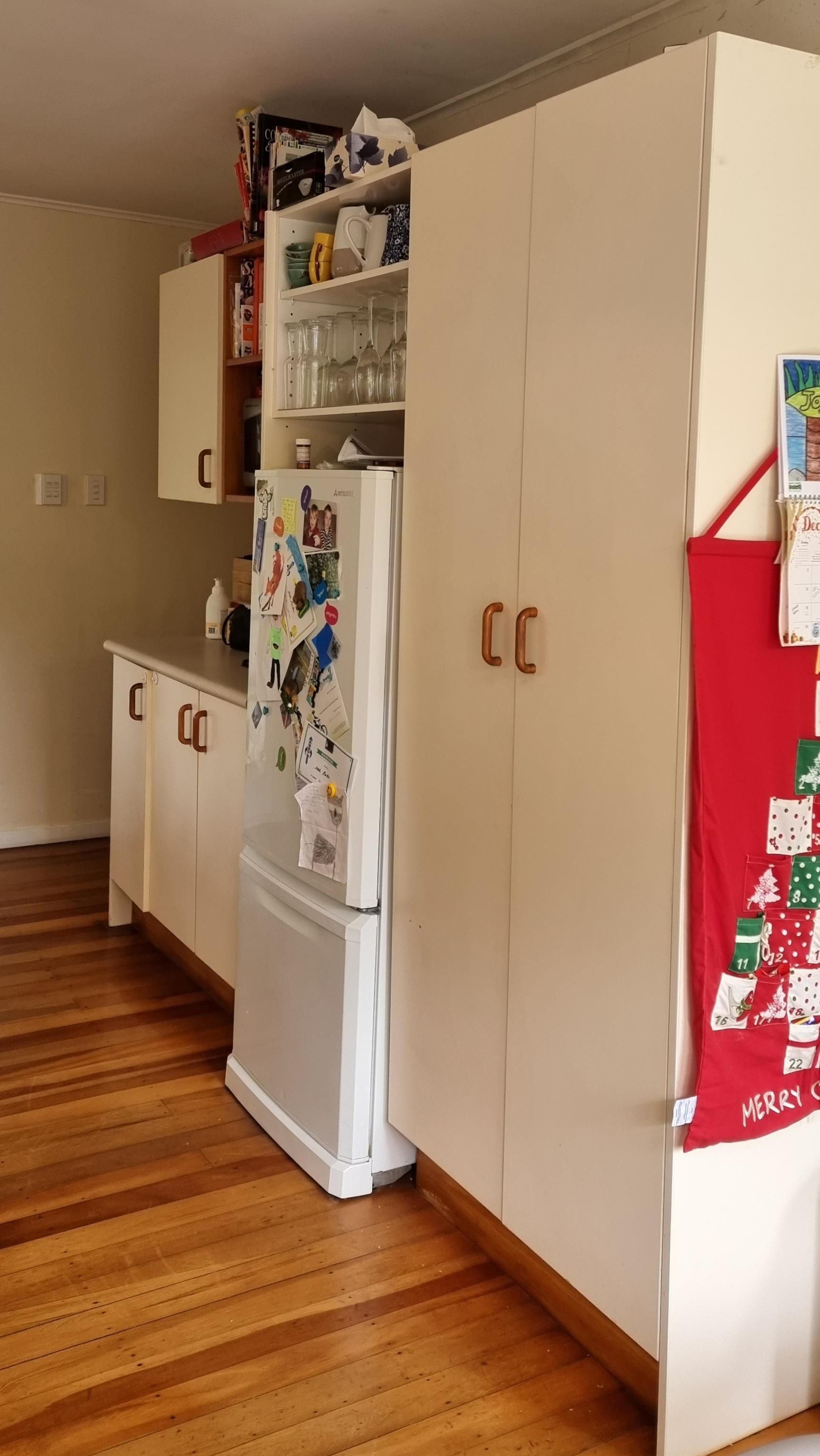 A kitchen with a refrigerator and a christmas tree on the wall