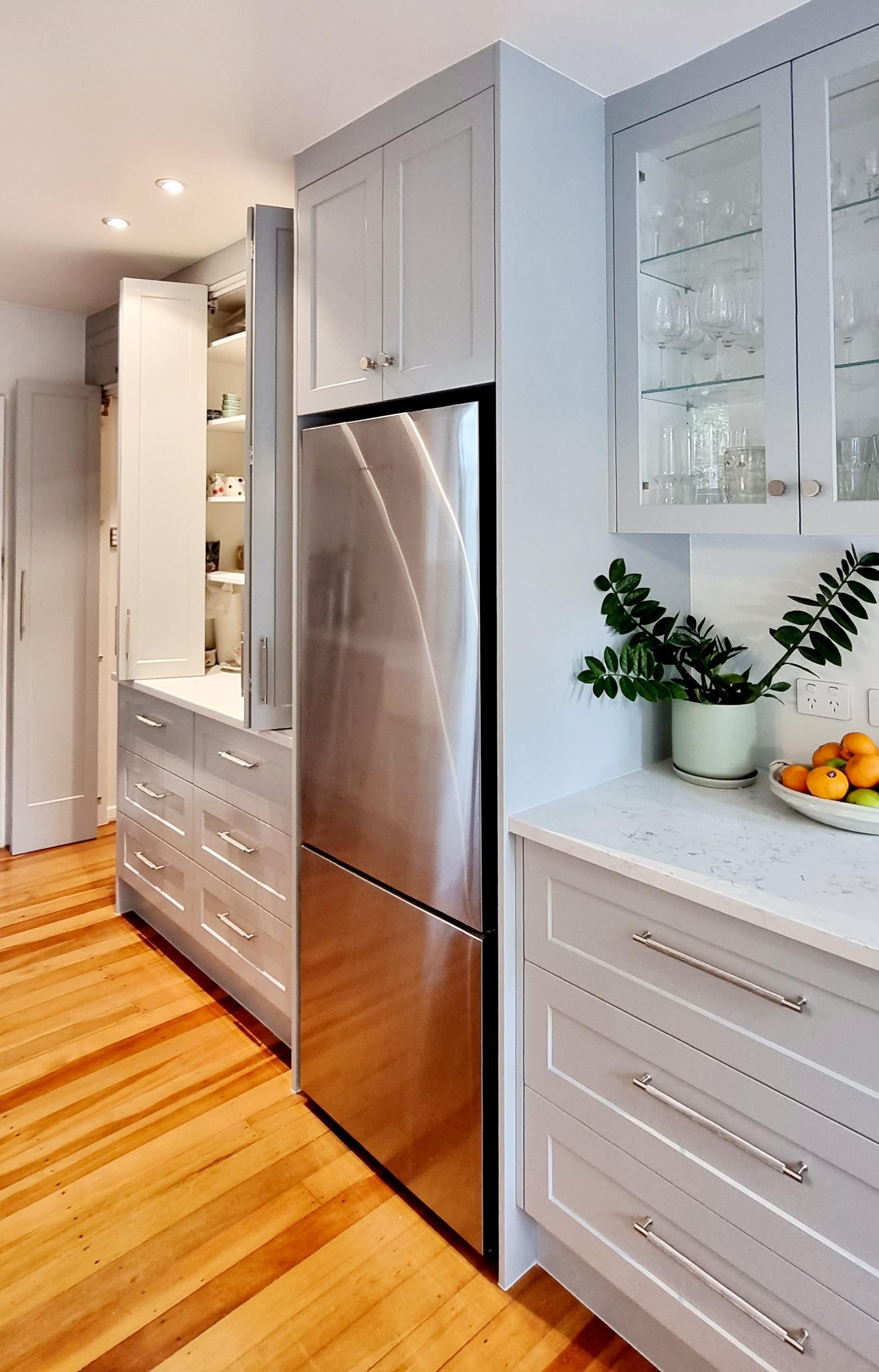 A kitchen with stainless steel appliances and wooden floors