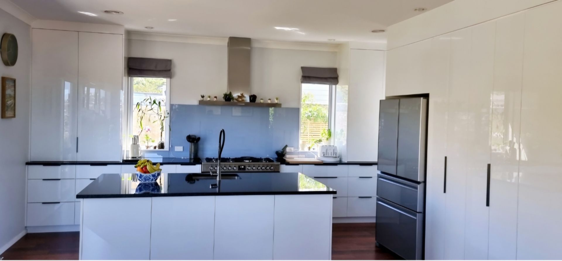 A kitchen with white cabinets and black counter tops