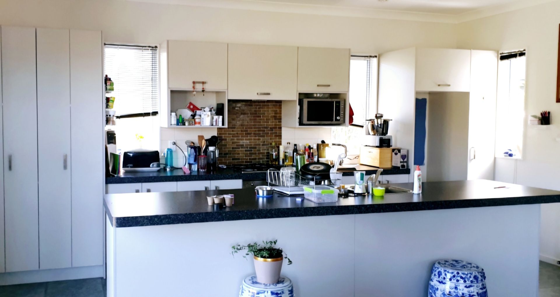 A kitchen with white cabinets and black counter tops