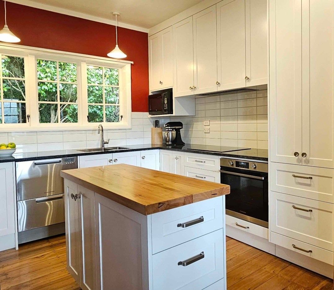 A kitchen with white cabinets and stainless steel appliances
