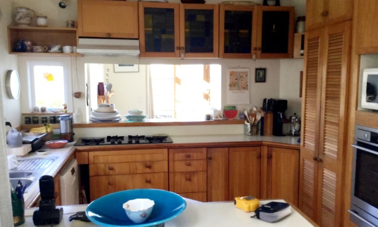 A kitchen with wooden cabinets and a blue bowl on the counter