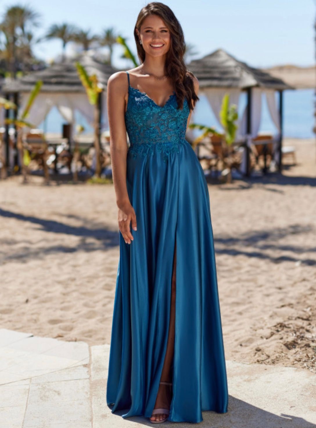 Eine Frau in einem blauen Kleid steht an einem Strand