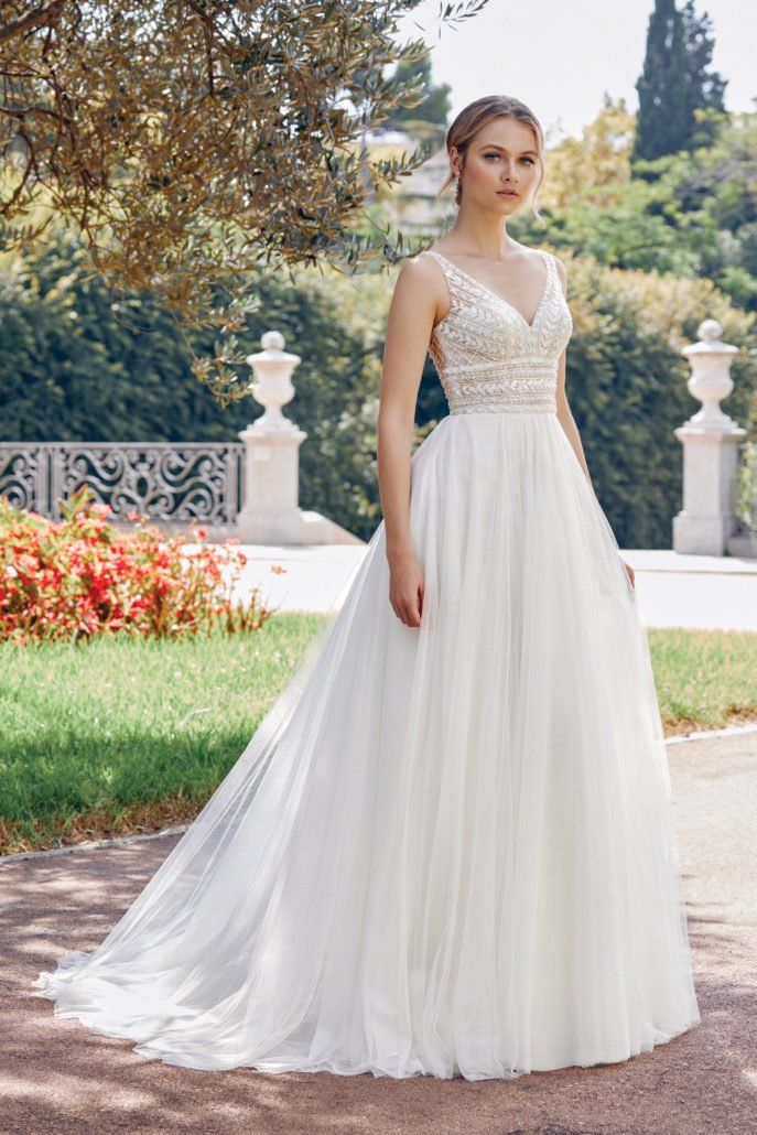 Eine Frau in einem weißen Brautkleid steht in einem Park.