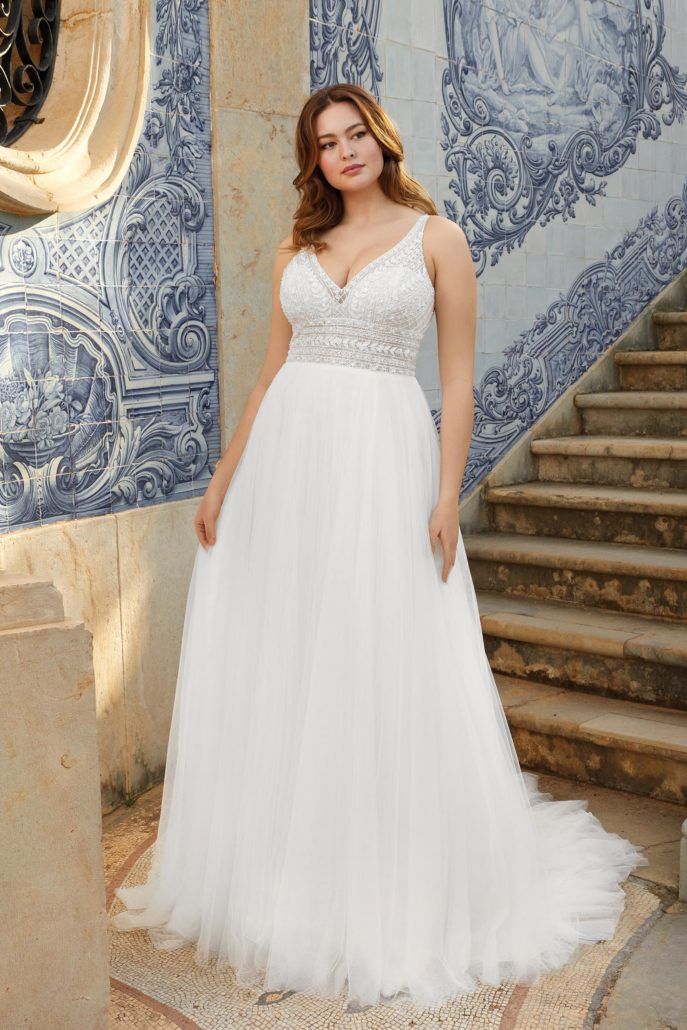 Eine Frau in einem weißen Brautkleid steht auf einer Treppe.