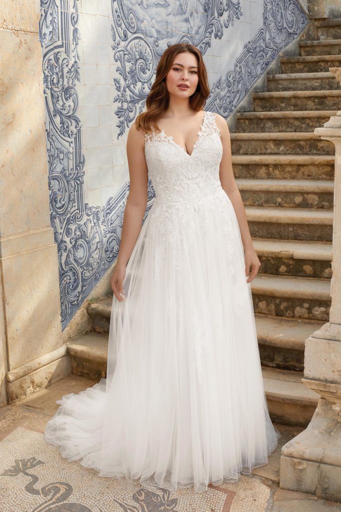 Eine Frau in einem weißen Brautkleid steht auf einer Treppe.