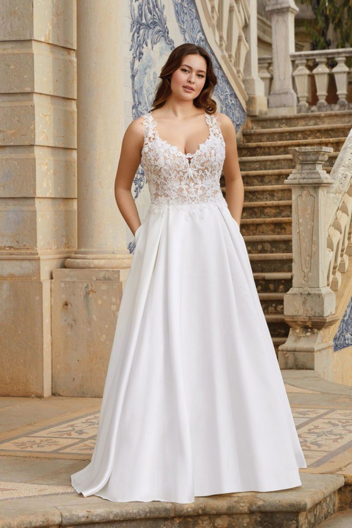Eine Frau in einem weißen Brautkleid steht auf einer Treppe.