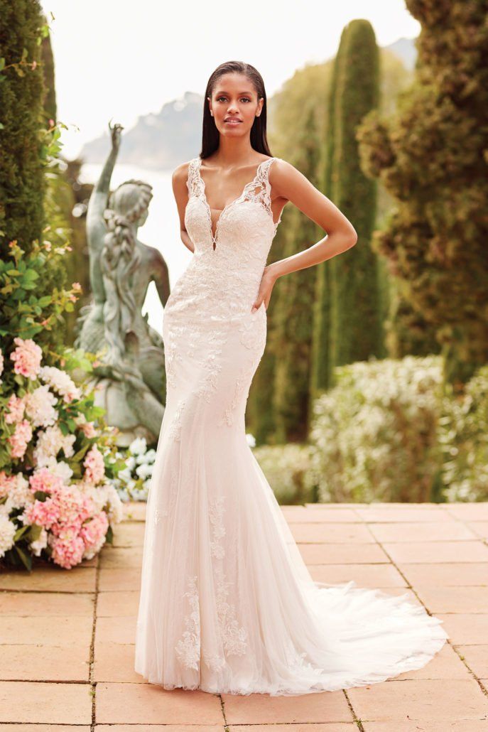 Eine Frau in einem weißen Hochzeitskleid steht vor einer Statue.
