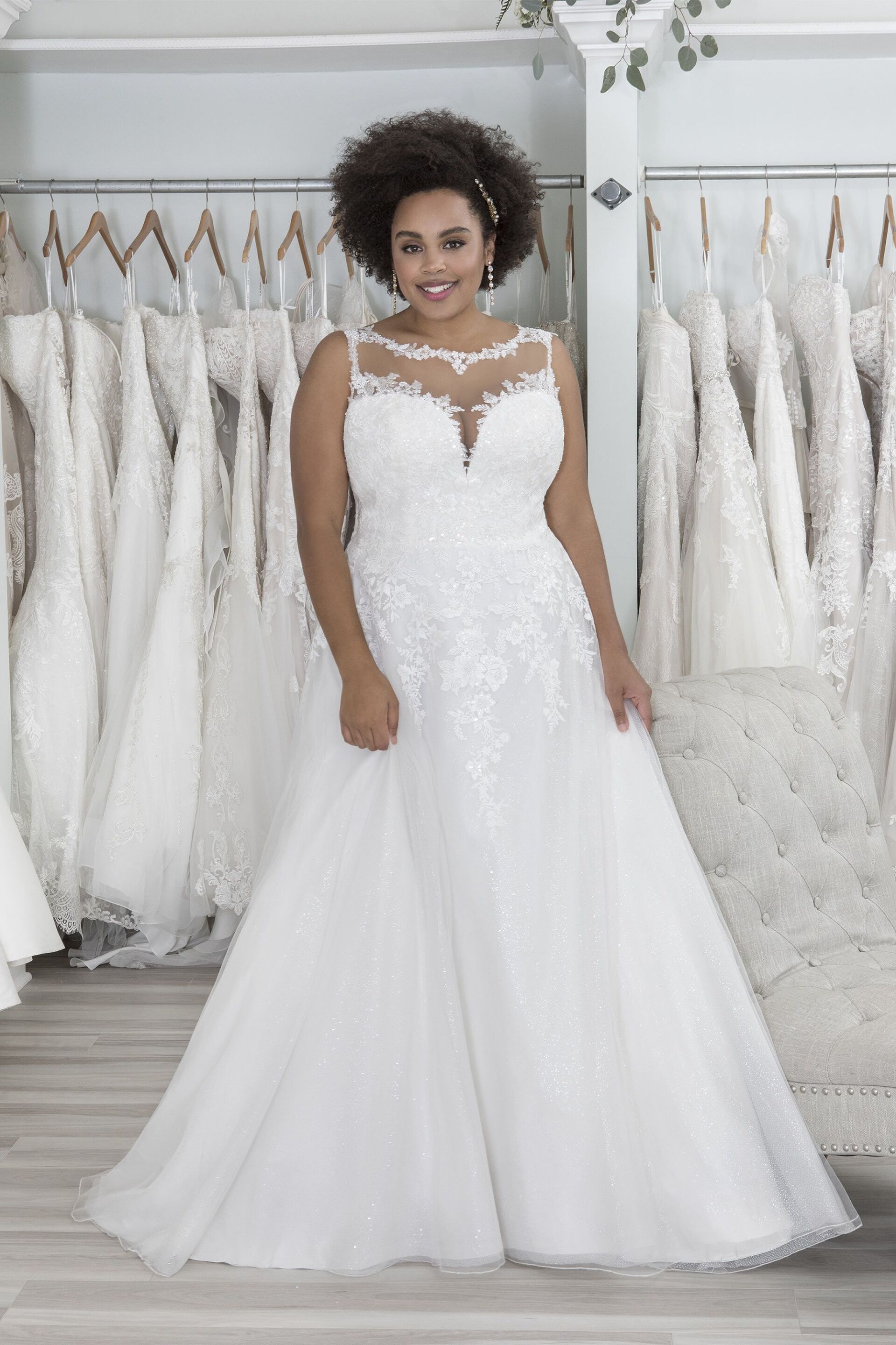 Eine Frau mit Übergröße trägt in einem Brautmodengeschäft ein weißes Brautkleid.