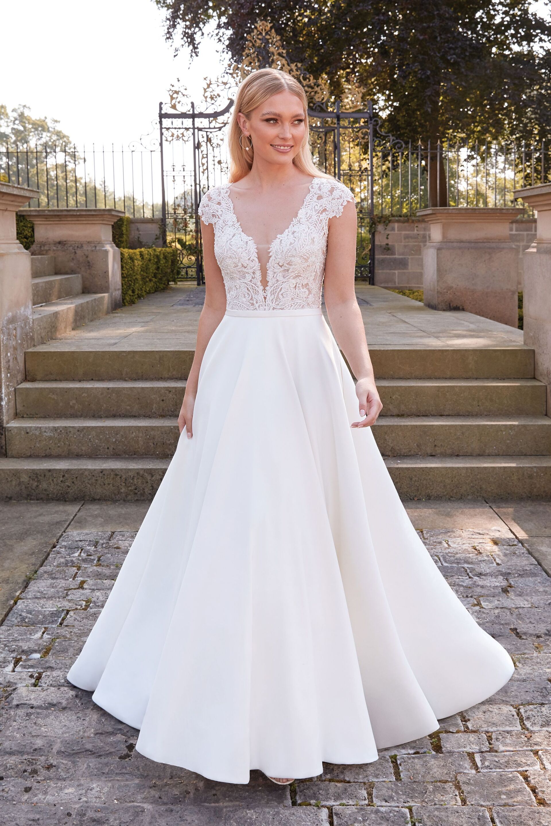Eine Frau in einem weißen Brautkleid steht auf einer Treppe.
